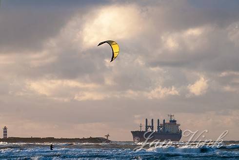 Vrachtschip, binnenlopend, bij Noordpier, vanaf het strand bij Velsen-Noord